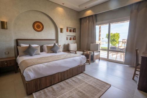 a bedroom with a large bed and a large window at True Beach Resort in Marsa Alam City