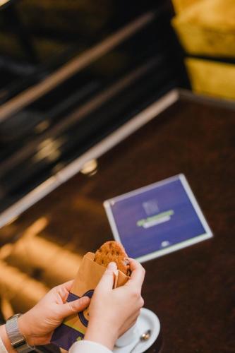 a person is eating a sandwich on a table at DoubleTree By Hilton Izmir Airport in Izmir