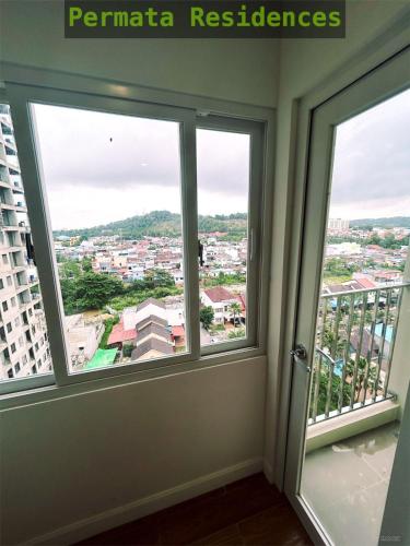 a room with two windows with a view of a city at Apartemen Permata Residences Baloi in Nagoya