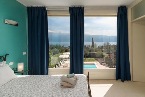 1 dormitorio con cama y ventana grande en Villa Oleandri, con Piscina privata e Vista Lago, en Bogliaco