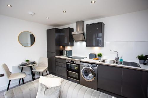 Il comprend une cuisine équipée d'un évier et d'un lave-linge. dans l'établissement Roker Sea Front Entire Modern One Bed Apartment, à Sunderland