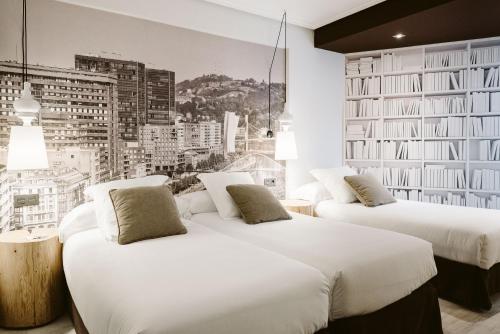 two beds in a hotel room with a city at Hotel Abando in Bilbao
