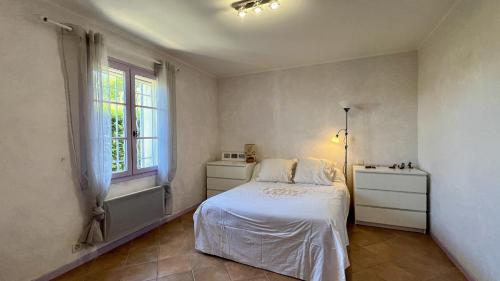 um quarto com uma cama branca e uma janela em Villa Saint Roch em Malaucène