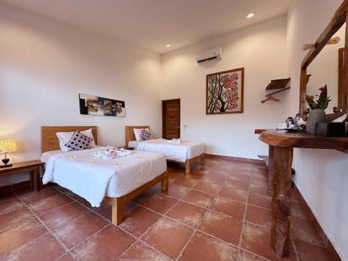 een slaapkamer met 2 bedden in een kamer bij Pebble & Fins Bali Dive Resort in Tulamben