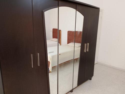 a black cabinet with a mirror in a room at Bella casa in Tataouine