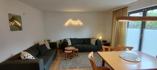 sala de estar con sofá y mesa en Pension Bergblick, en Ruhpolding