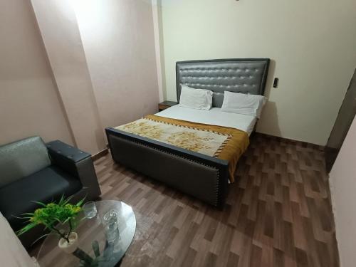 a small bedroom with a bed and a chair at Hotel Lahore City in Lahore