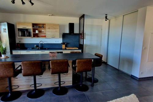een keuken met een grote tafel en een aantal stoelen bij Appartement moderne*vue mer*accès plage in Solaro