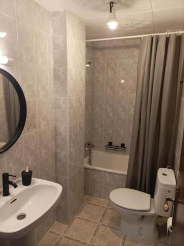 a bathroom with a toilet and a sink and a tub at Amplio apartamento Blanes in Blanes