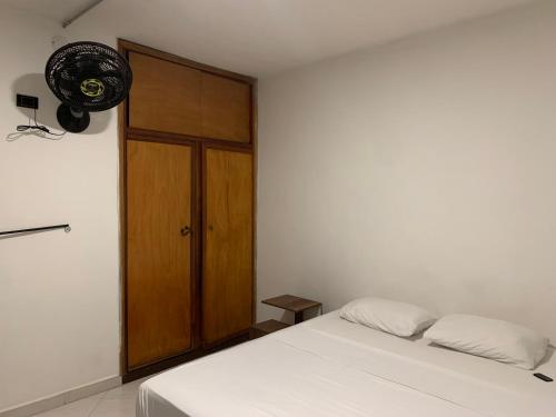 a bedroom with a bed and a wooden cabinet at La Familia Hostel - Manila in Medellín