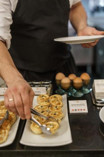 a man is preparing donuts on a table at Hotel Carlton in Bilbao