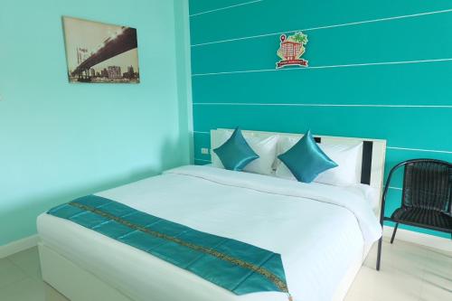 een slaapkamer met een bed met een blauwe muur bij Phuket Andaman Place ภูเก็ตอันดามันเพลส in Phuket