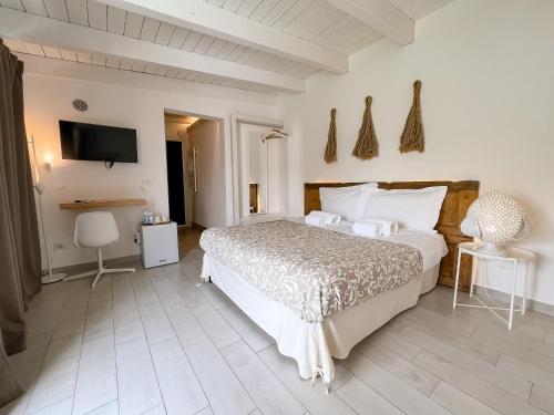ein Schlafzimmer mit einem großen Bett und einem TV in der Unterkunft San Michele Luxury Rooms in Matera