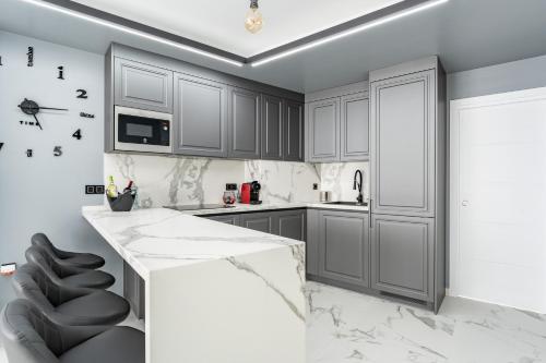 a kitchen with gray cabinets and a marble counter at Ensueños8 in Fuengirola