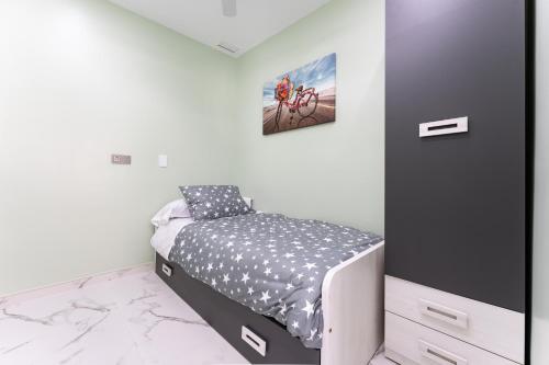 a small bedroom with a bed and a painting on the wall at Ensueños8 in Fuengirola