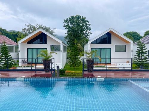 een villa met een zwembad voor een huis bij The Estretto Resort in Chiang Rai
