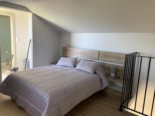 a bedroom with a large bed with a wooden headboard at Casa Jardim Panoramic View in Estreito da Calheta