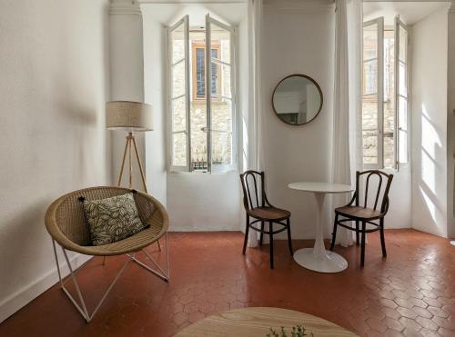 sala de estar con mesa, sillas y espejo en A CASA ROSSA L'Olivier, en Saint-Paul-de-Vence