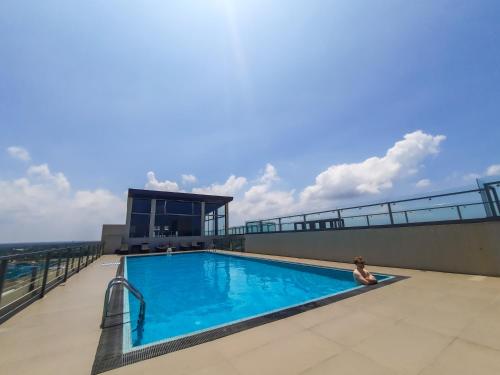 une femme assise au bord d'une piscine dans un bâtiment dans l'établissement Sea Wave, à Negombo