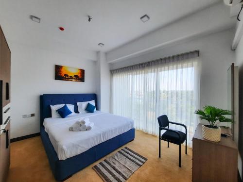 um quarto com uma cama azul e uma cadeira em Sea Wave em Negombo