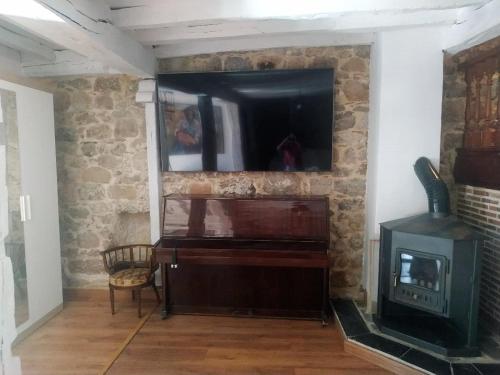 a living room with a television and a stove at Apto. La Magnolia cerca de Comillas y playas in La Virgen