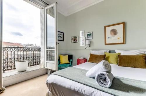 a bedroom with a large bed and a balcony at L'Ecrin - Lumineux et Vues splendides -Batignolles in Paris