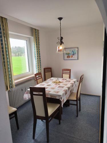 een eetkamer met een tafel en stoelen en een raam bij Haus Christine in Halblech