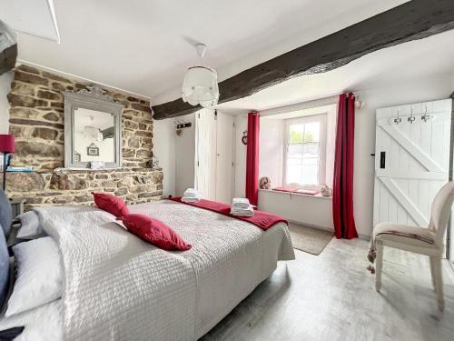 MontpinchonにあるChambres d'Hôtes La Clef des Champsのベッドルーム1室(赤い枕が付いた大型ベッド1台付)