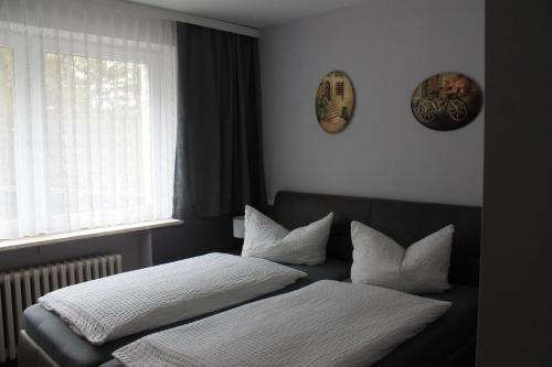 a bedroom with a bed with two pillows and a window at Hotel Carolaruh in Bad Elster