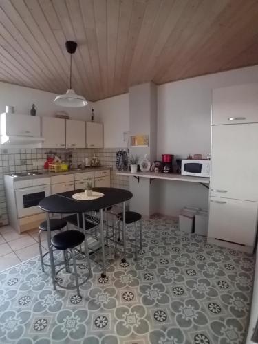 une cuisine avec une table, des chaises et un réfrigérateur dans l'établissement appartement spacieux dans joli village alsacien, à Châtenois