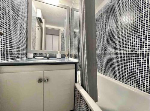 La salle de bains est pourvue d'un lavabo, d'une baignoire et d'un miroir. dans l'établissement Appart vue mer et Esterel-Piscine, à Saint-Raphaël