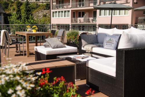 een patio met banken en een tafel op een balkon bij MONDI Hotel Bellevue Gastein in Bad Gastein