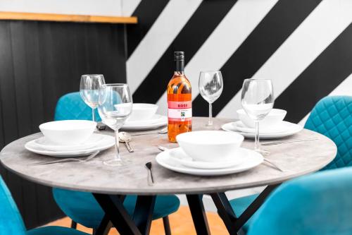 un tavolo con bicchieri e una bottiglia di vino di Luxury 3 Bed House - Garden - Parking - Netflix - Wifi 