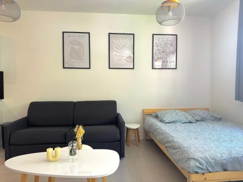 un salon avec un lit et une table dans l'établissement Grand studio rénové proche mer !, à Nice
