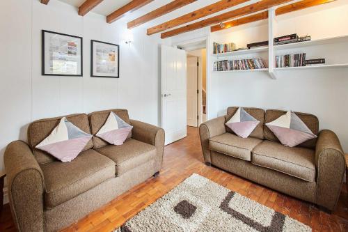 una sala de estar con 2 sofás y una alfombra en Host & Stay - Trefor Cottage en Trevor