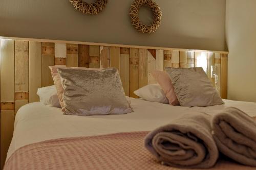 a bed with white sheets and pillows in a bedroom at Wolfsveld - dicht bij strand en duinen! in Castricum