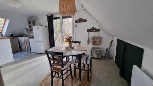 une cuisine et une salle à manger avec une table et des chaises dans l'établissement Les Balcons du Canet, à Gonneville-sur-Honfleur