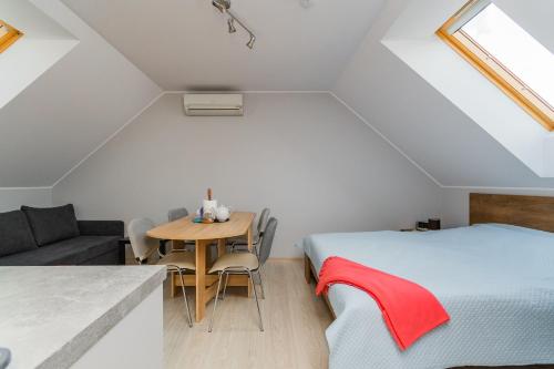 a bedroom with a bed and a table and a couch at Villa del Sol in Sztutowo