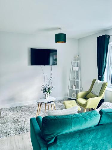 a living room with a green couch and two chairs at Dover Port in quiet location with Castle Views and off road parking in Kent
