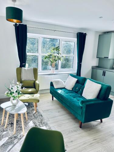 a living room with a green couch and two chairs at Dover Port in quiet location with Castle Views and off road parking in Kent