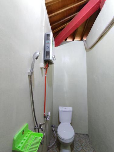a small bathroom with a toilet and a phone at Omah Joglo Sukorejo RedPartner in Sukareja
