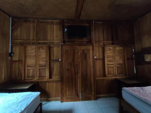 Habitación con armarios de madera y TV de pantalla plana. en Omah joglo RedPartner, 