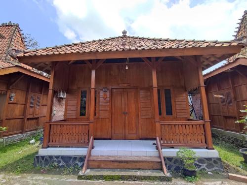 een houten huis met een grote houten deur bij Omah joglo RedPartner 