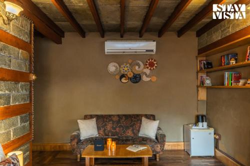 a living room with a couch and a table at StayVista at The Manor with Mountain View & Fireplace in Manāli