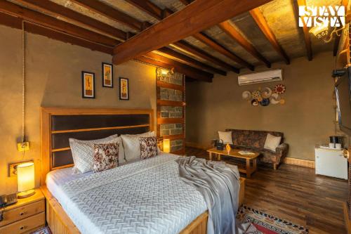 a bedroom with a large bed and a couch at StayVista at The Manor with Mountain View & Fireplace in Manāli