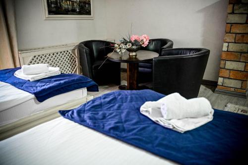 a room with two chairs and a table with towels at Hotel Centar Balasevic in Belgrade
