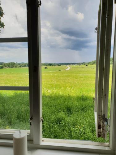 une fenêtre ouverte donnant sur un champ d'herbe dans l'établissement Pilgrimscenter, 