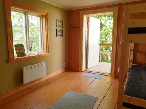 ein leeres Zimmer mit zwei Fenstern und Holzboden in der Unterkunft Pilgrimscenter 