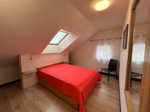a bedroom with a red bed and a window at Villa Marmillons in Aix-les-Bains