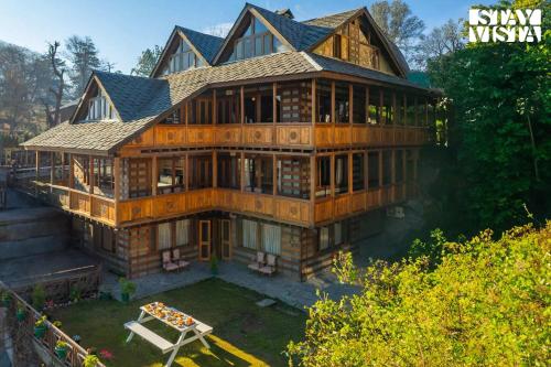 an aerial view of a large wooden house at StayVista at The Manor with Mountain View & Fireplace in Manāli